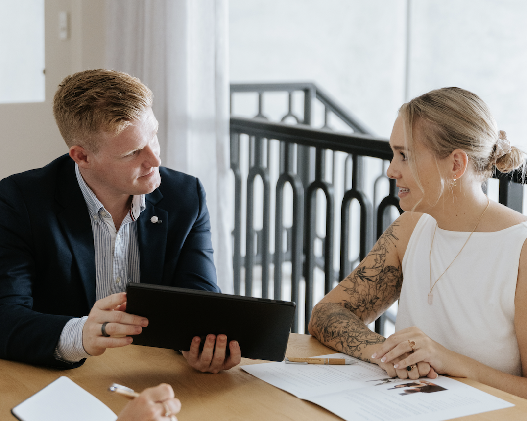 Screenshot 2025-09-25 at 7.56.27 AM Young male accountant showing female graph on tablet